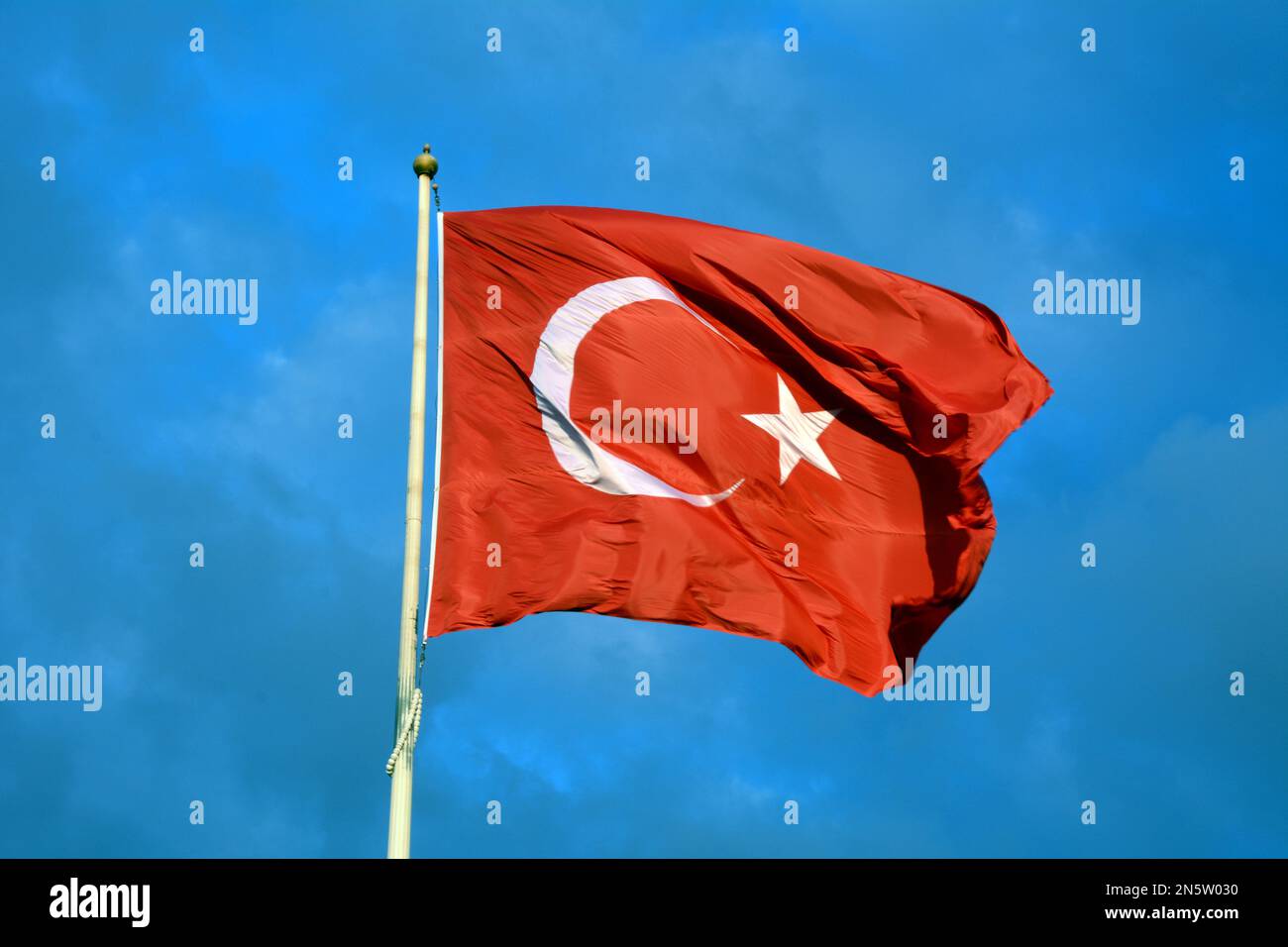 Una grande bandiera turca che sventola nel vento sopra Piazza Taksim nel quartiere Beyoglu di Istanbul, sul lato europeo, della Turchia. Foto Stock
