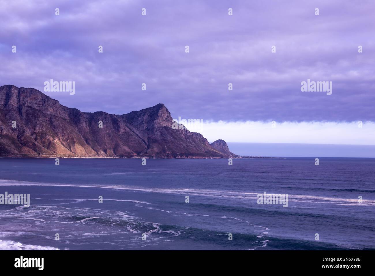 Mare scuro con la montagna e le nuvole Foto Stock