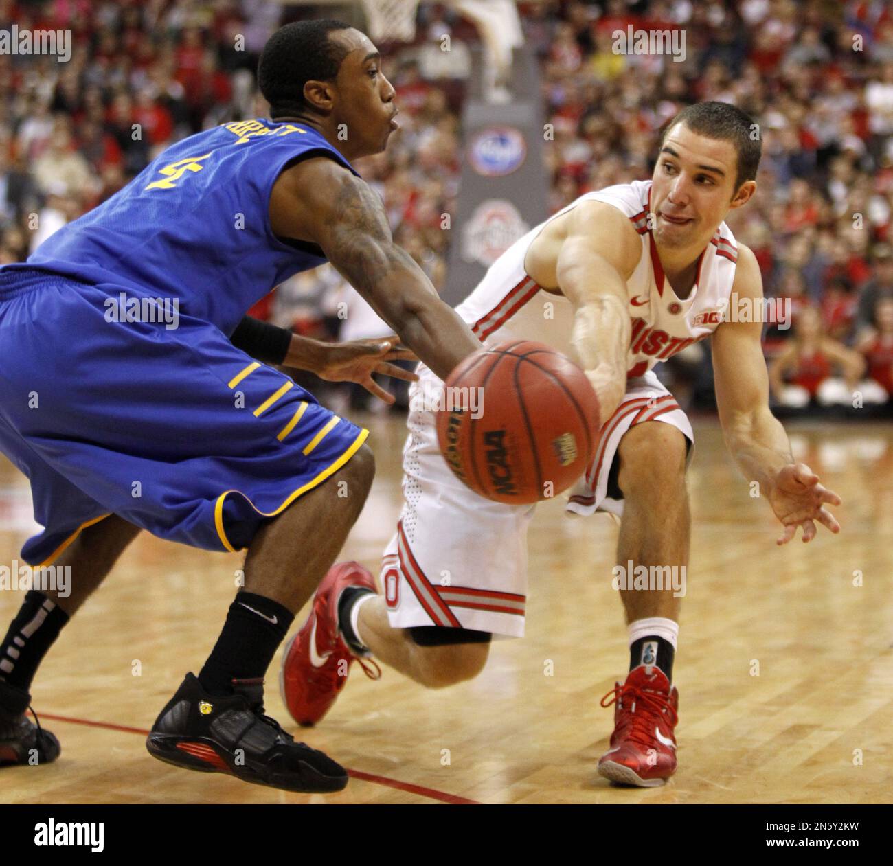 Ohio State's Aaron Craft, right, tries to pass the ball around Delaware's Jarvis Threatt during an NCAA college basketball game in Columbus, Ohio, Wednesday, Dec. 18, 2013. (AP Photo/Paul Vernon) Foto Stock