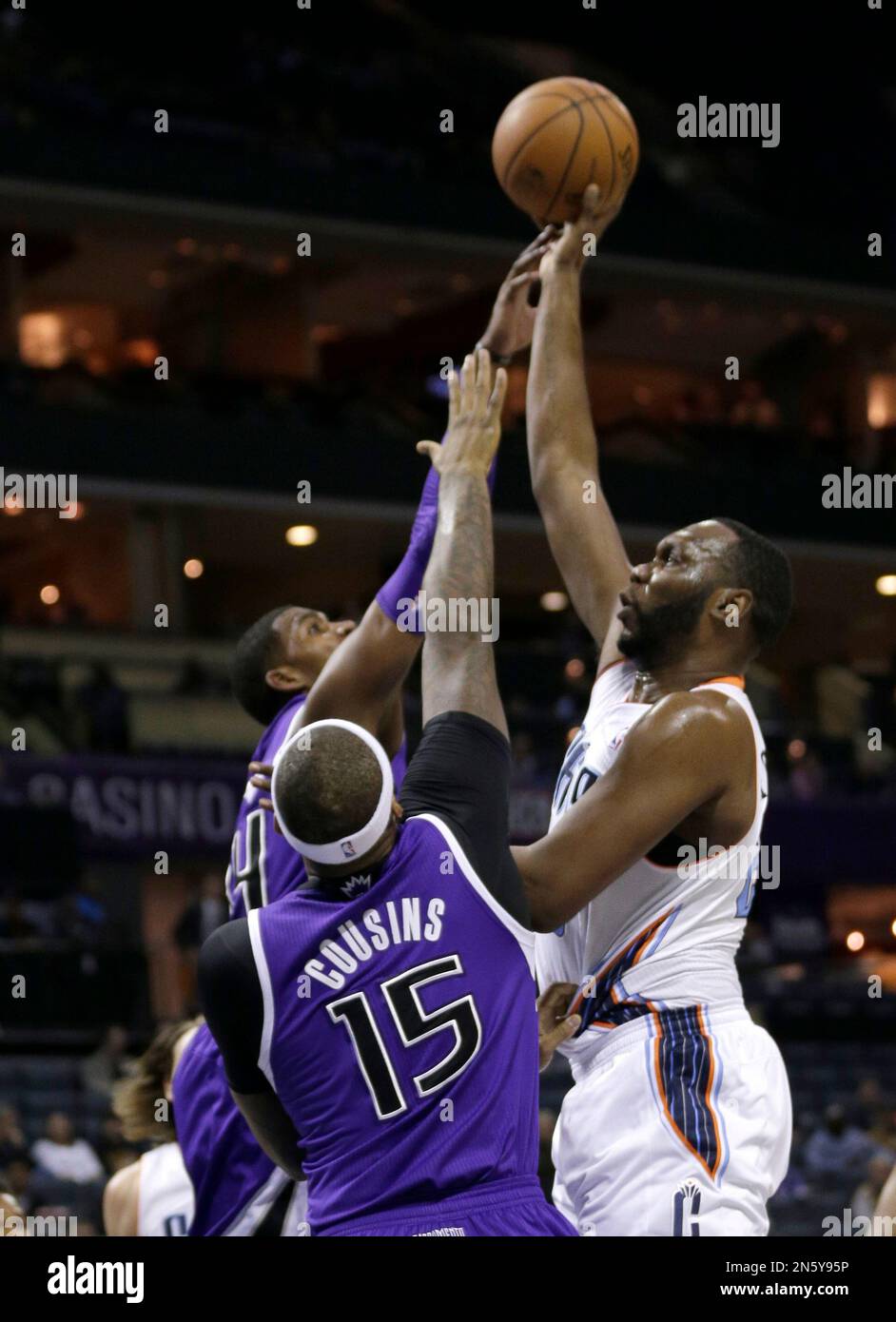 Charlotte Bobcats' Al Jefferson, right, shoots over Sacramento Kings' DeMarcus Cousins, left, during the first half of an NBA basketball game in Charlotte, N.C., Tuesday, Dec. 17, 2013. (AP Photo/Chuck Burton) Foto Stock