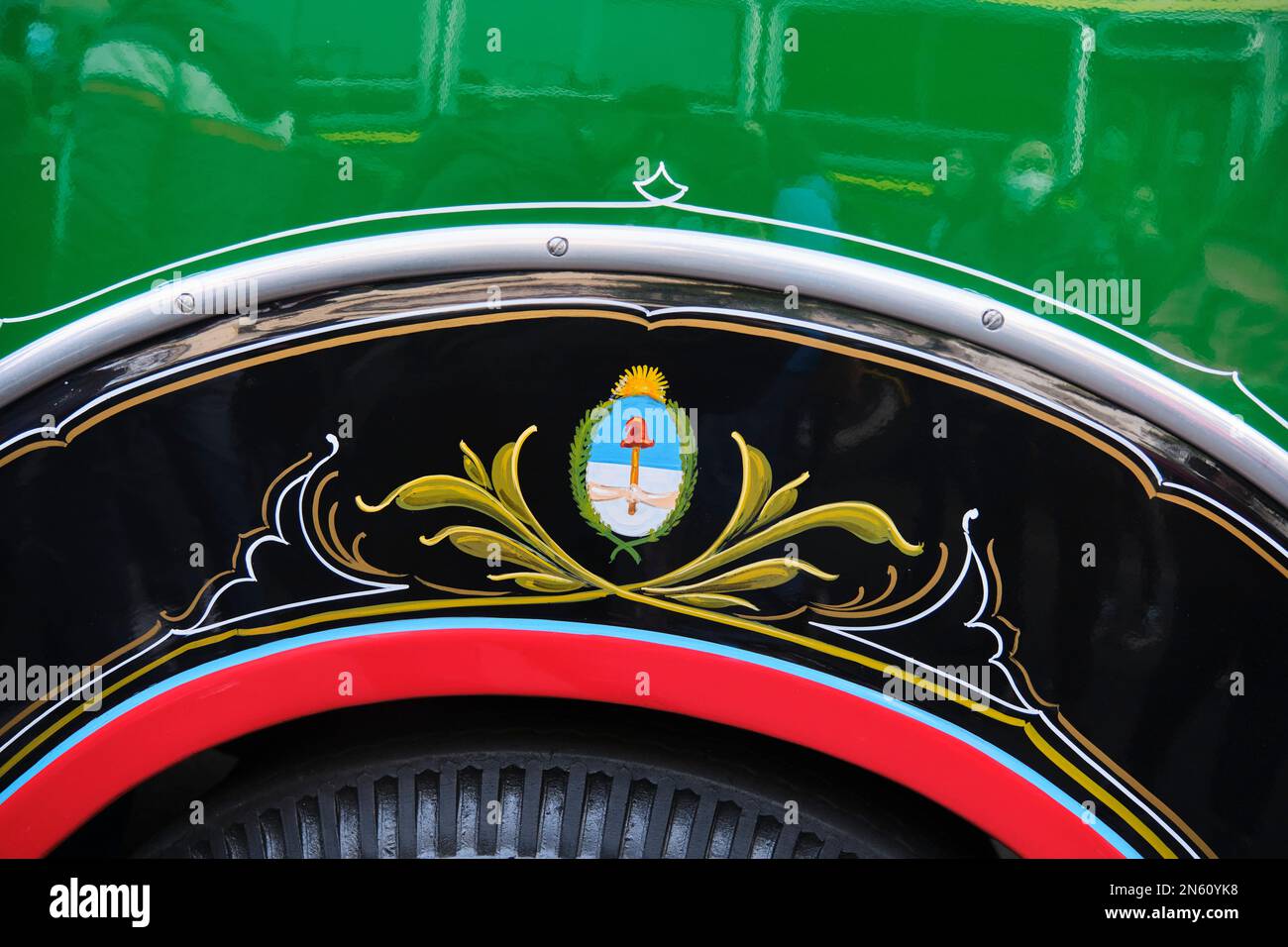 Buenos Aires, Argentina, 20 giugno 2022: Dettaglio decorativo sulla carrozzeria di un bus Chevrolet 1942, linea 45. Scudo nazionale argentino nel fileteado Foto Stock