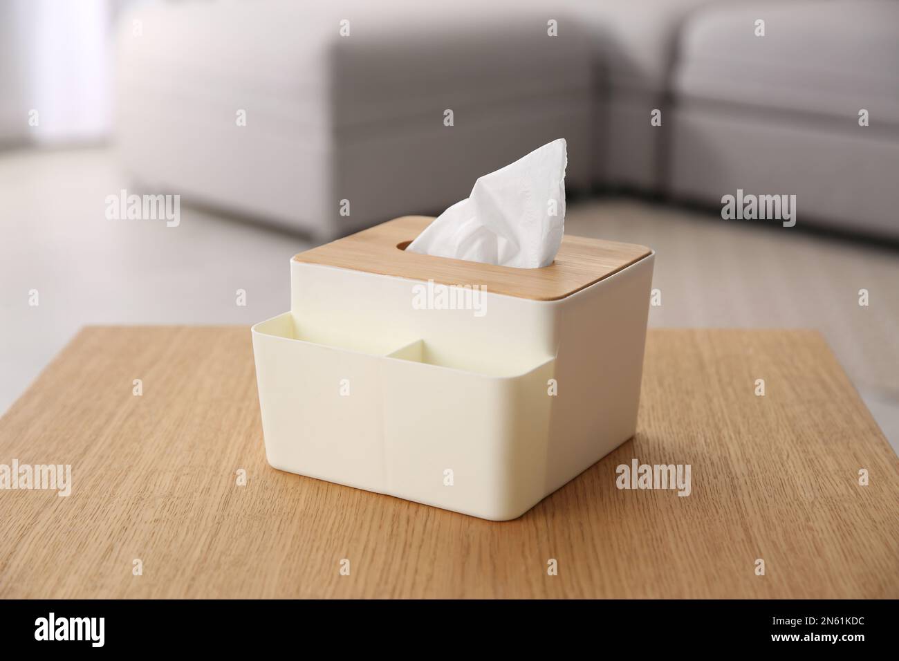 Scatola con fazzolettini di carta su tavolo di legno in soggiorno Foto Stock