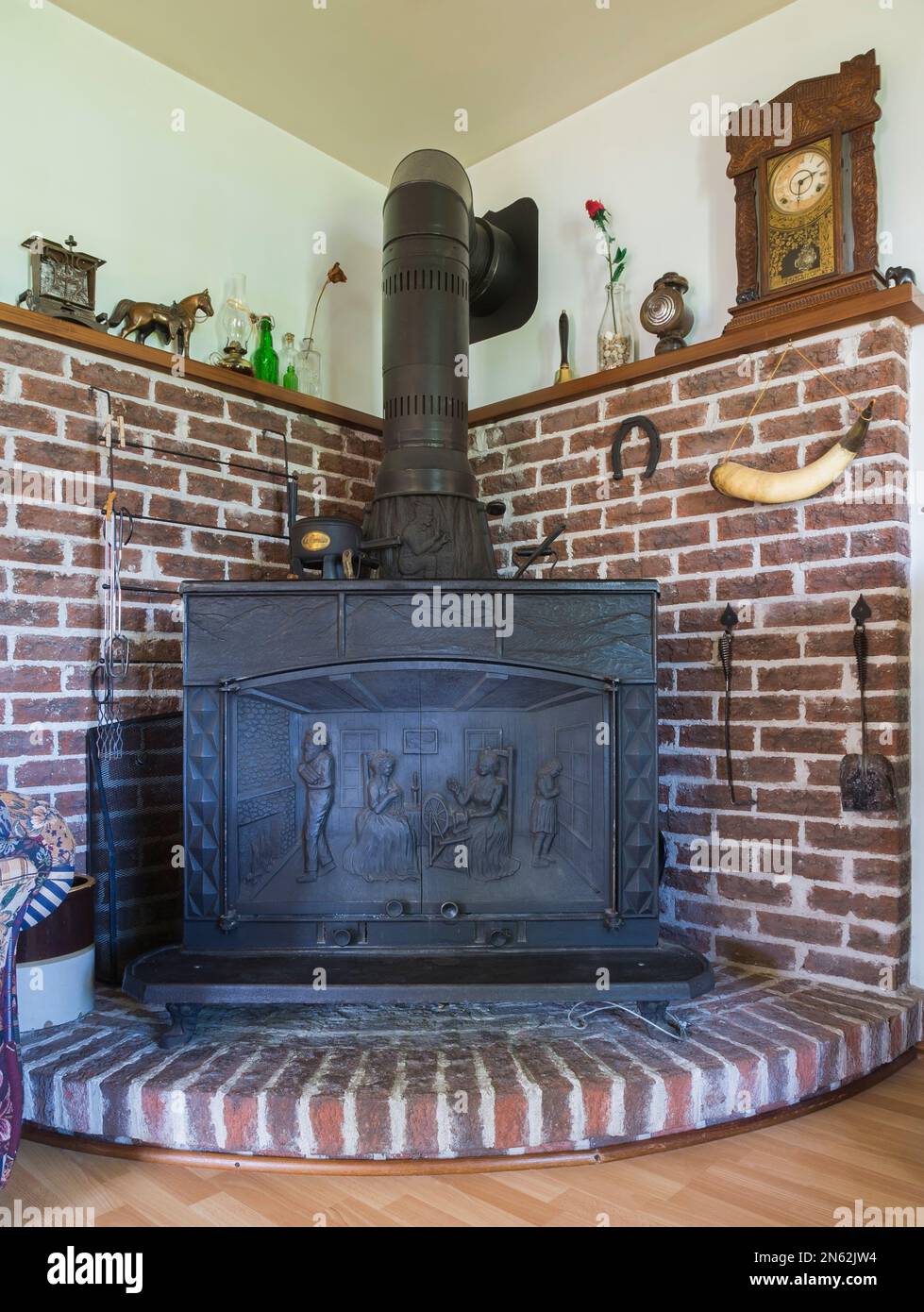 Stufa a legna Franklin a riproduzione 1977 montata su piattaforma in mattoni rialzati nel soggiorno all'interno di una vecchia casa in stile cottage canadese del 1927. Foto Stock