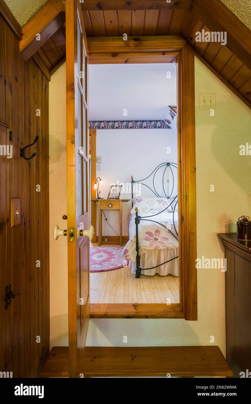 Guardando dalla porta aperta del bagno privato, si accede alla camera da letto principale al piano superiore all'interno della vecchia casa del 1927. Foto Stock