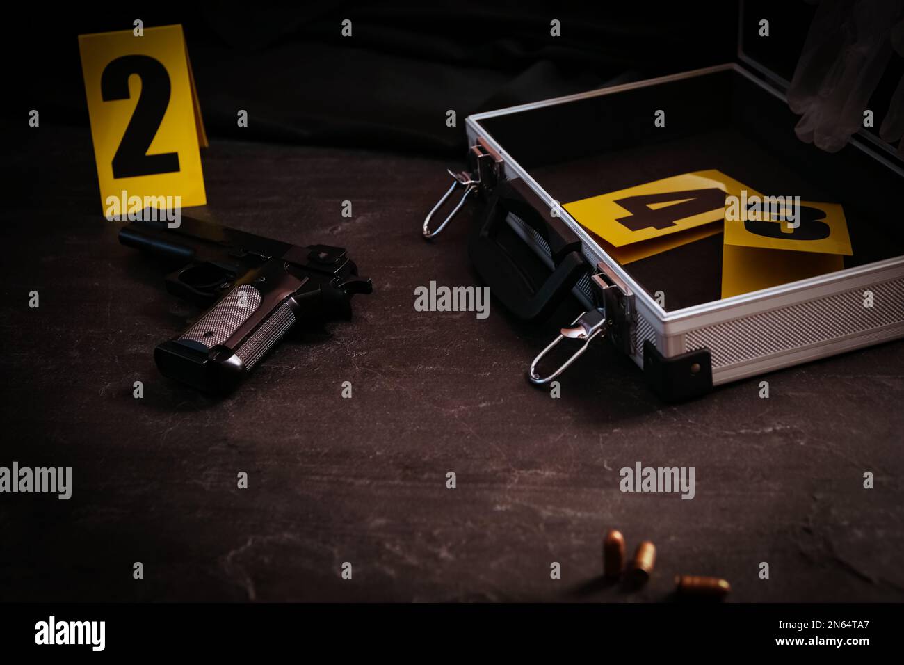 Pistola e custodia aperta con indicatori di prova sul tavolo nero ardesia. Scena del crimine Foto Stock