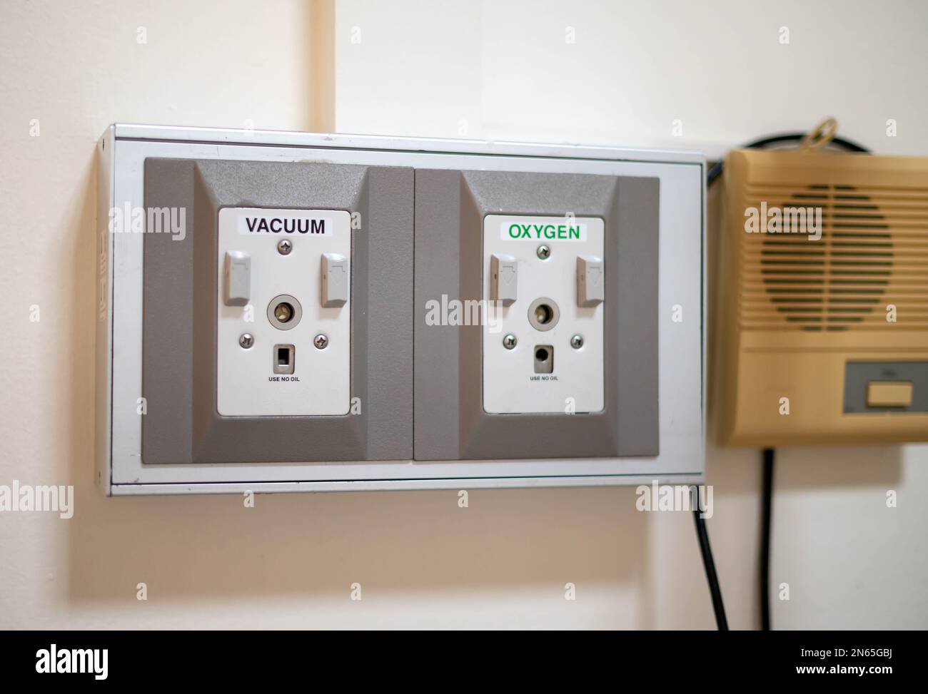 Primo piano di apparecchiature mediche, fornitura di gas ossigeno e vuoto su una parete del reparto ospedaliero. Foto Stock