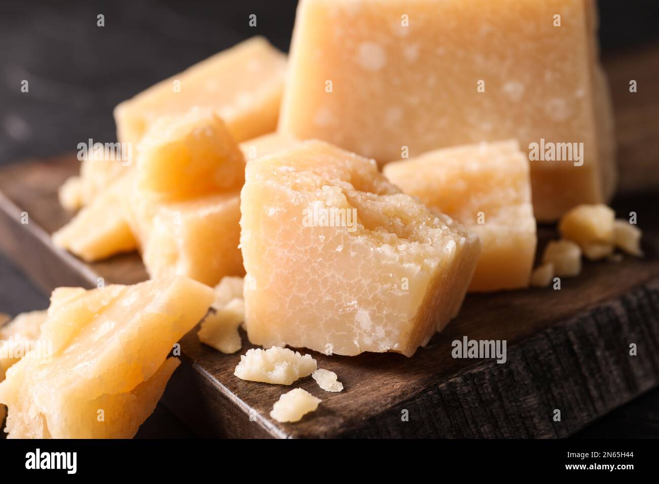 Pezzi di delizioso parmigiano su tavola di legno, primo piano Foto Stock