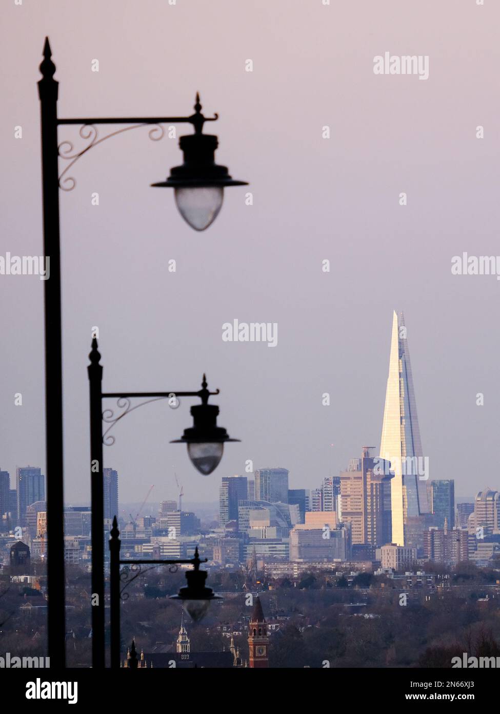 Londra, Regno Unito. Lampioni a Gipsy Hill con lo skyline della City of London e lo Shard Building visto in lontananza. Foto Stock