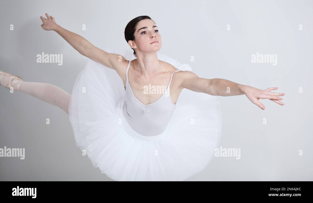 Ballare con grazia. Ballerina giovane e flessibile che balla su sfondo bianco. Foto Stock