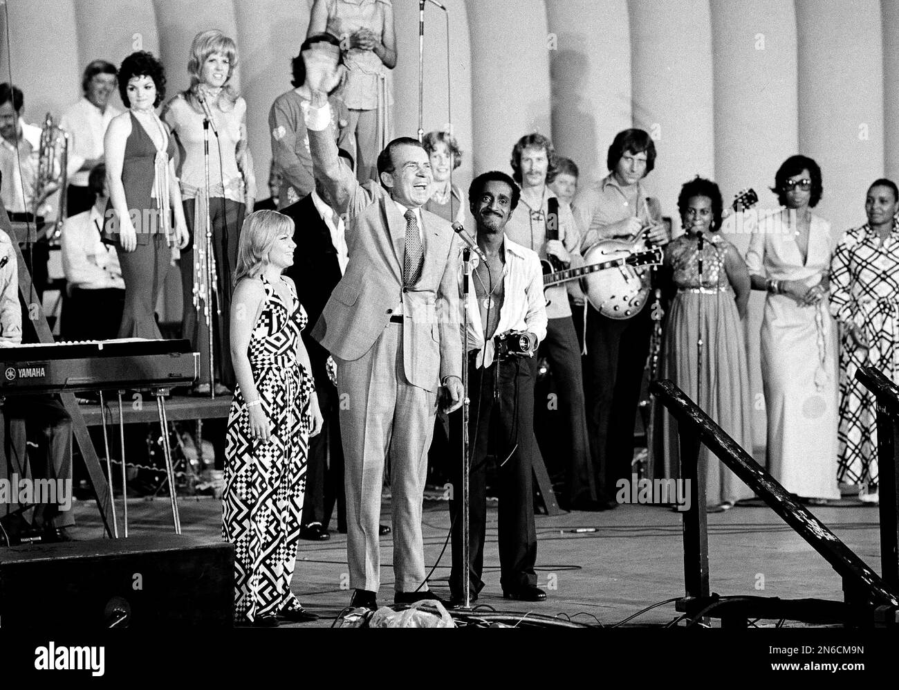 U.S. President Richard M. Nixon waves to an estimated 8,000 of his youthful supporters at a youth rally in Marine Stadium, Aug. 22, 1972 in Miami Beach, Fla., after the Republican National Convention nominated him for re-election. With him are Pam Powell, head of Young Voters for the President, and Sammy Davis, Jr., the rally master of ceremonies. (AP Photo) Foto Stock
