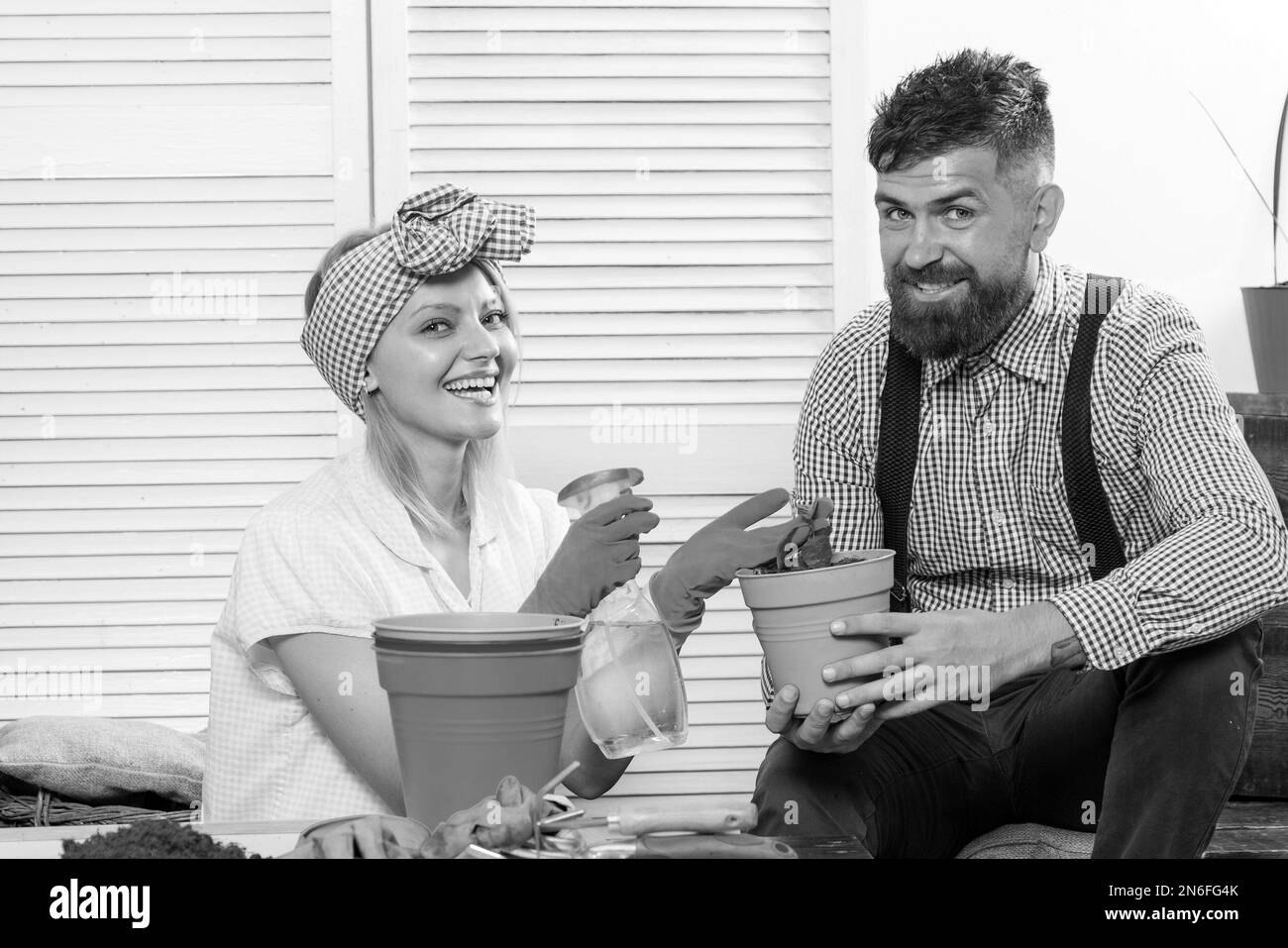 Giovane e felice coppia in amore piantando e divertirsi insieme. Amorevole marito aiuta la sua bella moglie nel giardinaggio. Felice famiglia giovane che passa il tempo Foto Stock