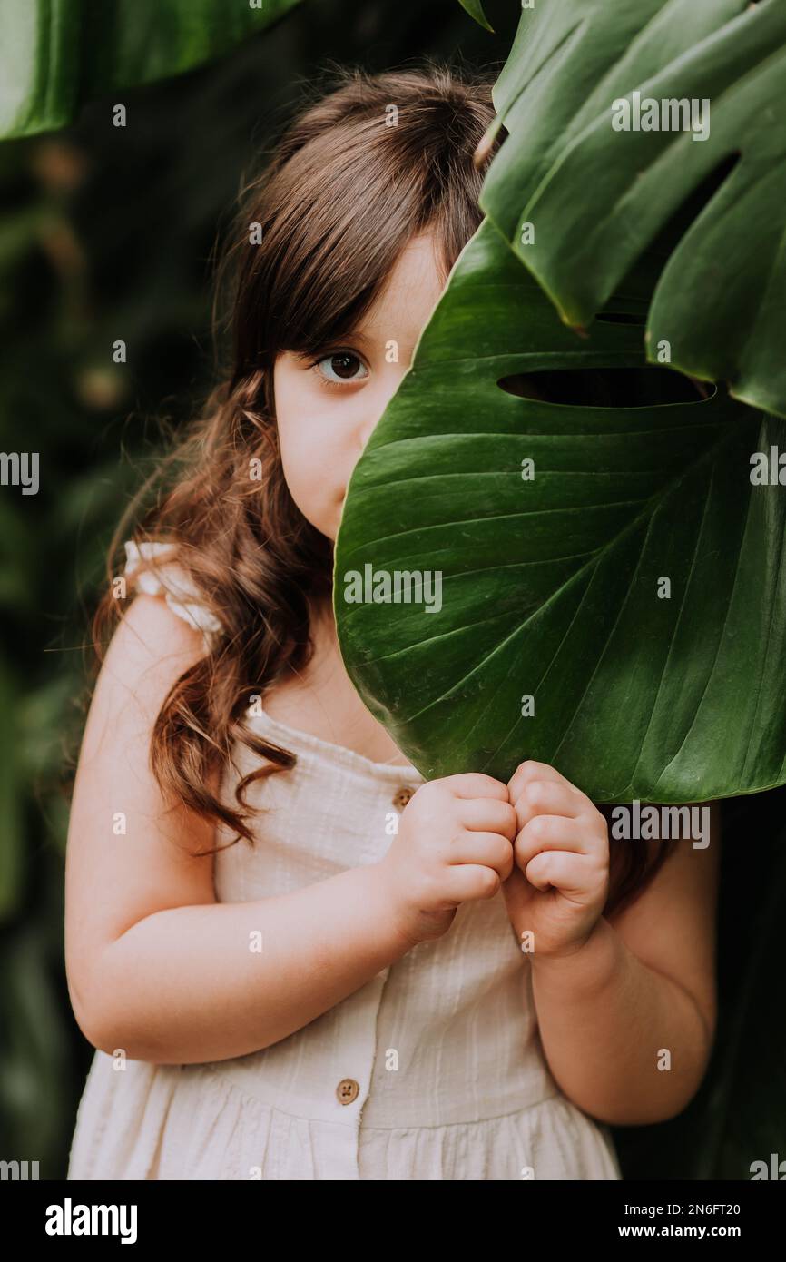 un bambino con una foglia di palma, uno spazio per il testo. Cosmetici naturali, ecologia, paesi esotici. Foto di alta qualità Foto Stock