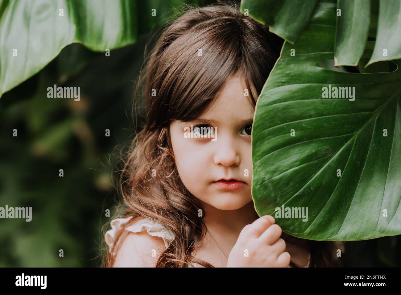 un bambino con una foglia di palma, uno spazio per il testo. Cosmetici naturali, ecologia, paesi esotici. Foto di alta qualità Foto Stock