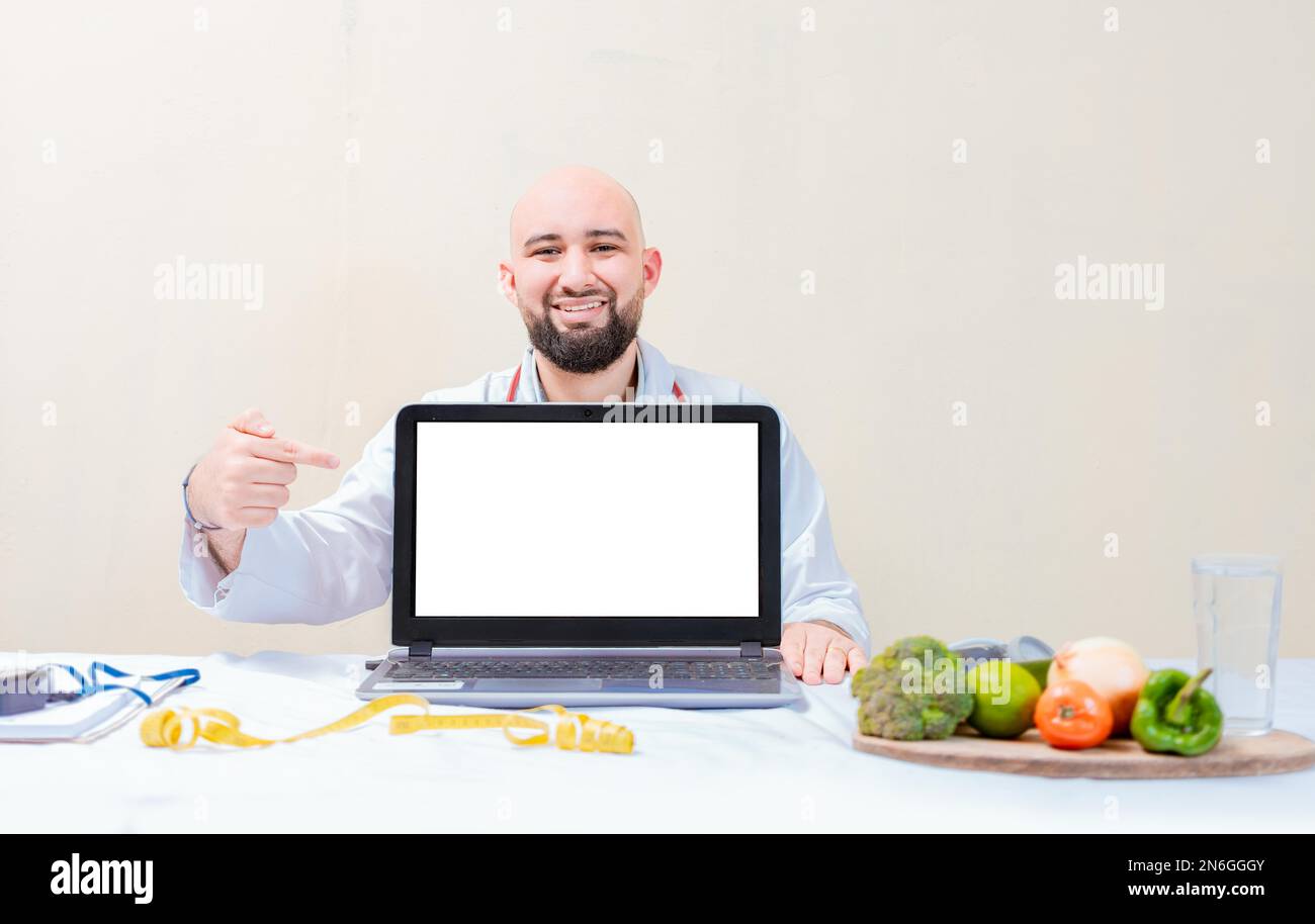 Nutrizionista sorridente che indica una pubblicità sul laptop, nutrizionista che indica lo schermo del laptop. Nutrizionista professionista che indica a. Foto Stock