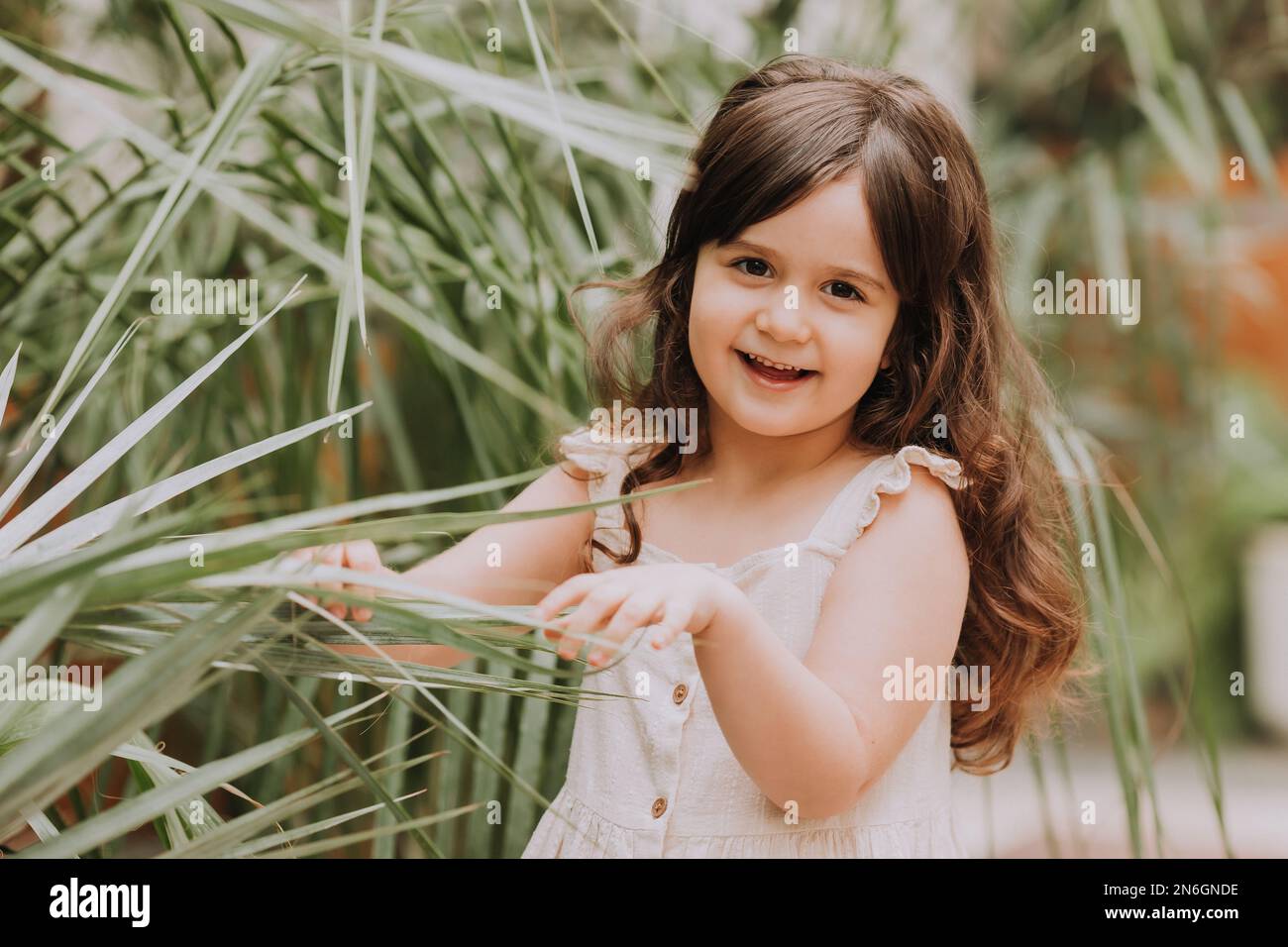 una bambina cammina nel giardino botanico. felice bambino e palme Foto Stock