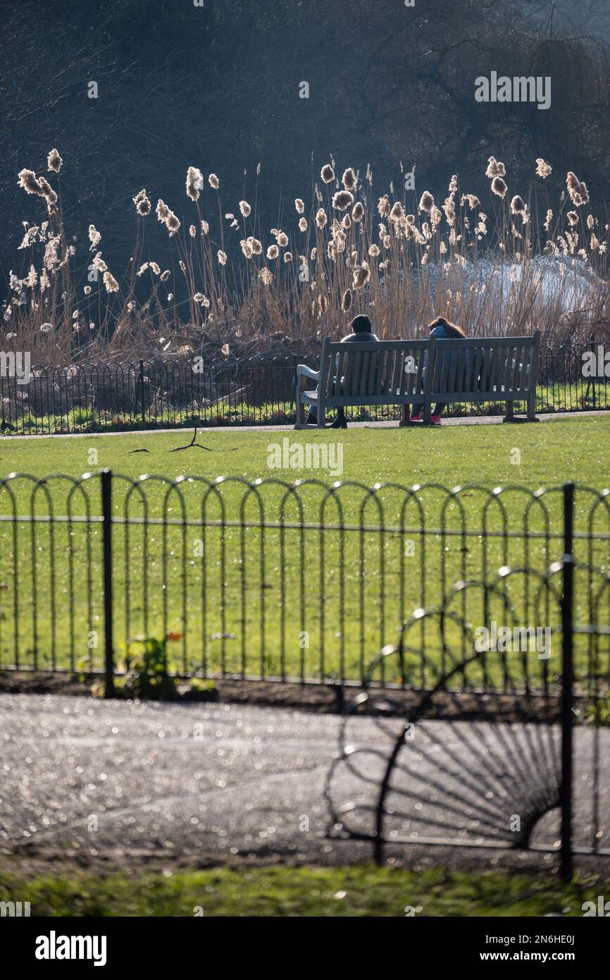 Londra, Inghilterra, Regno Unito. Due donne sedute su una panchina nel St James's Park, febbraio Foto Stock