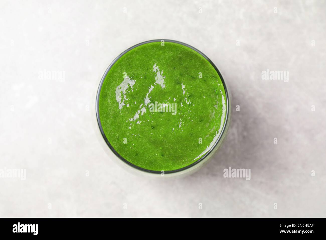 Delizioso succo fresco verde sul tavolo grigio, vista dall'alto Foto Stock