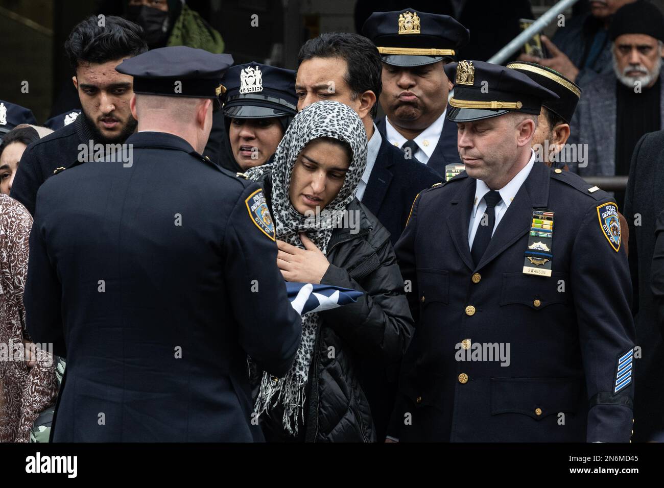 LA moglie DI PO Adeed Fayaz riceve la bandiera ripiegata NYPD ai suoi funerali al Makki Masjid Muslim Community Center di Brooklyn, New York, il 9 febbraio 2023 Foto Stock