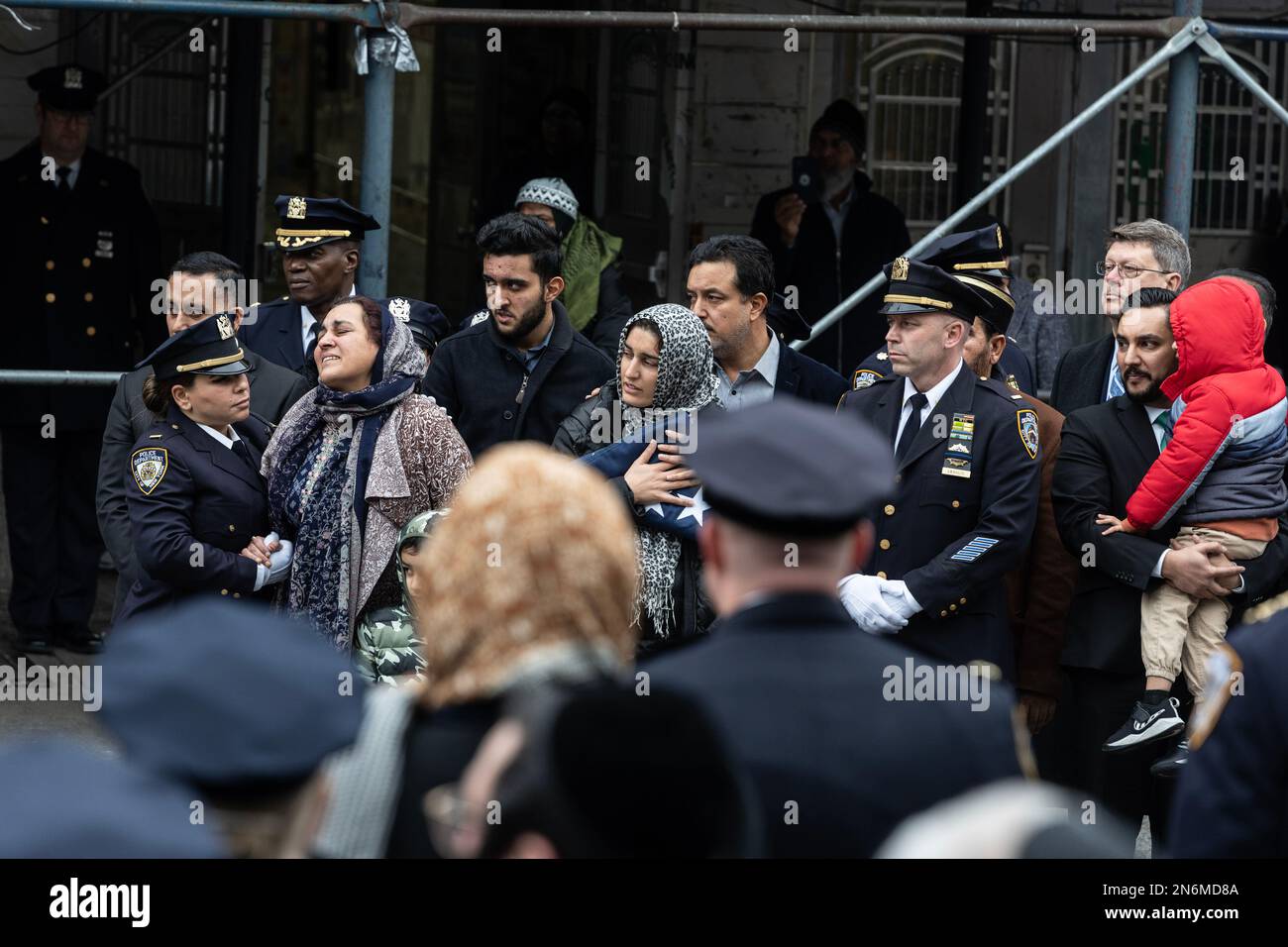 LA moglie DI PO Adeed Fayaz tiene la bandiera ripiegata di NYPD ai suoi funerali al Makki Masjid Muslim Community Center di Brooklyn, New York, il 9 febbraio 2023 Foto Stock