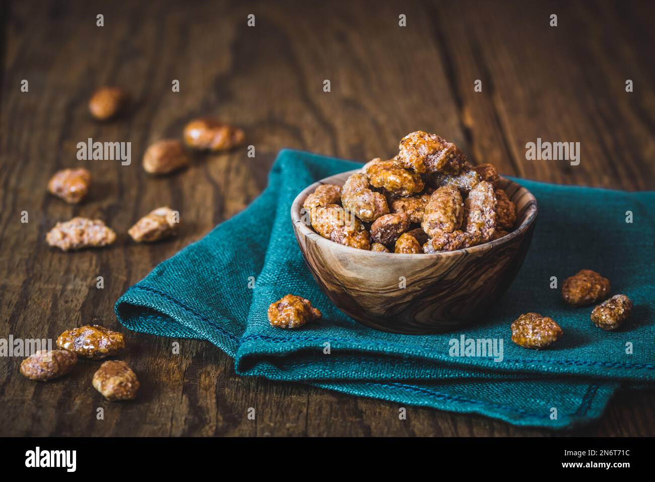 Ciotola di mandorle dolci candite su fondo rustico in legno Foto Stock