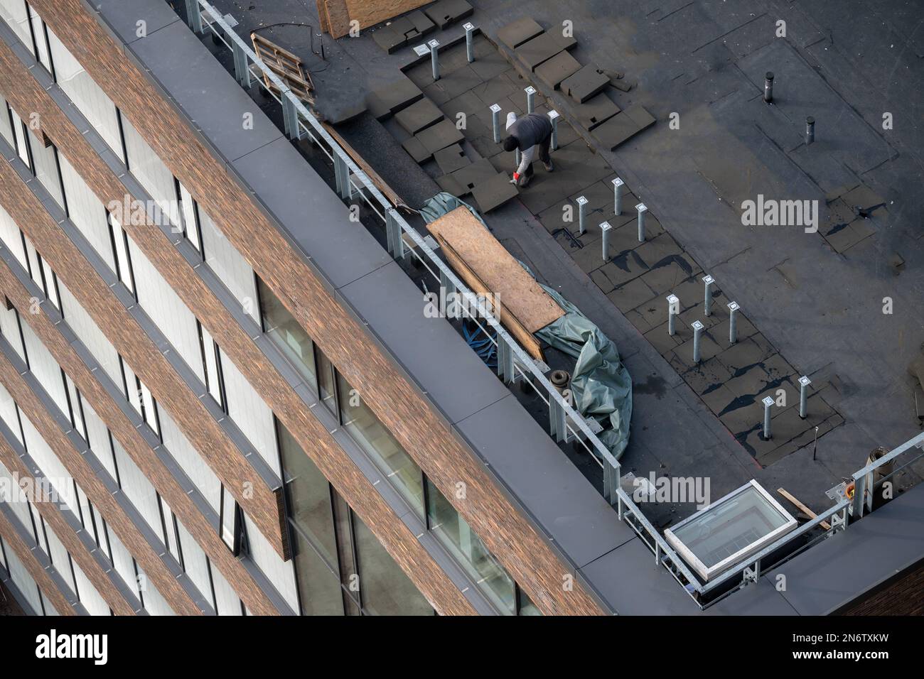 Vista ad occhio di uccello di un cantiere sul tetto. Impermeabilizzazione professionale del bitume su un edificio piano. Foto Stock