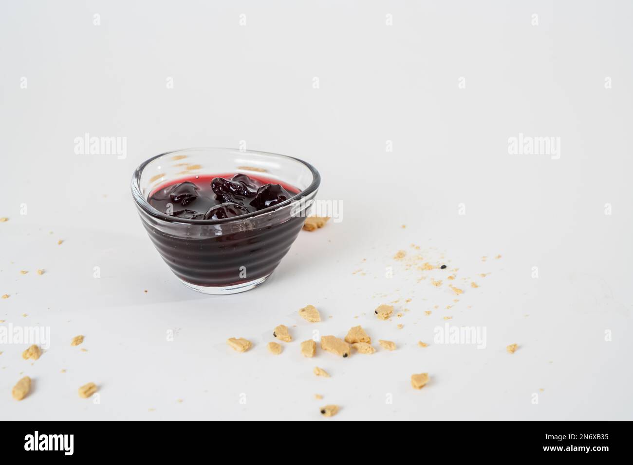 Marmellata di ciliegia acida fatta in casa, vasetto e ciotola piccola con marmellata isolata su sfondo bianco. Foto Stock
