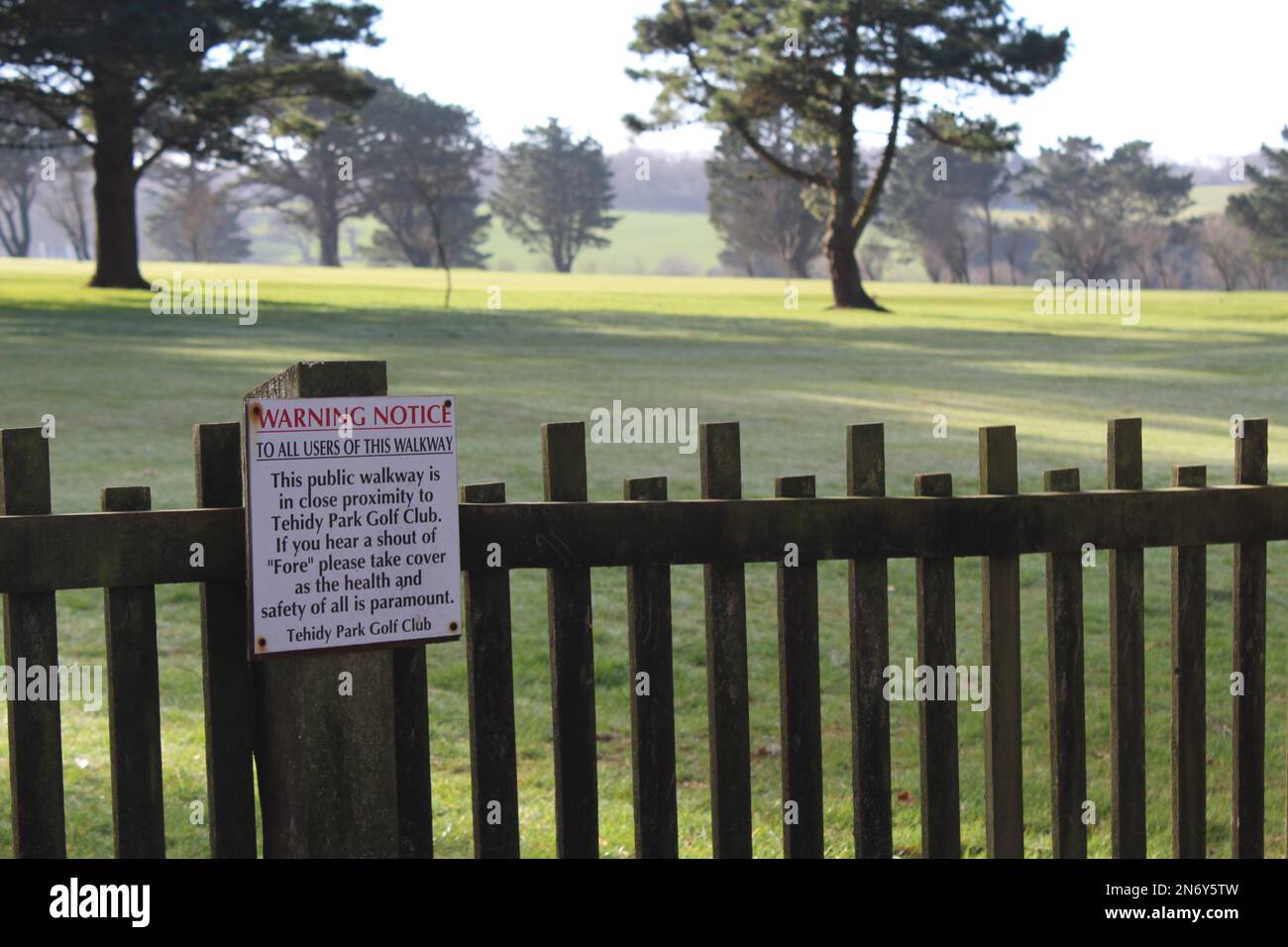 Cartello di avvertimento Tehidy Golf Course sulla recinzione dal diritto pubblico di strada a Tehidy Country Park, Cornovaglia, Inghilterra Foto Stock