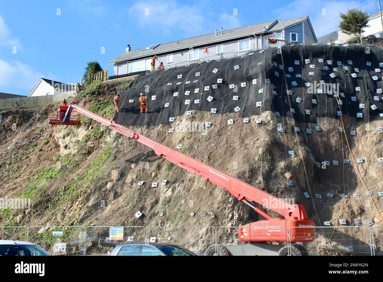 Lavori di stabilizzazione della scogliera presso il parcheggio di Quarry Lane a Falmouth, Cornovaglia, Inghilterra. I lavoratori in discesa svolgono un lavoro essenziale. Foto Stock