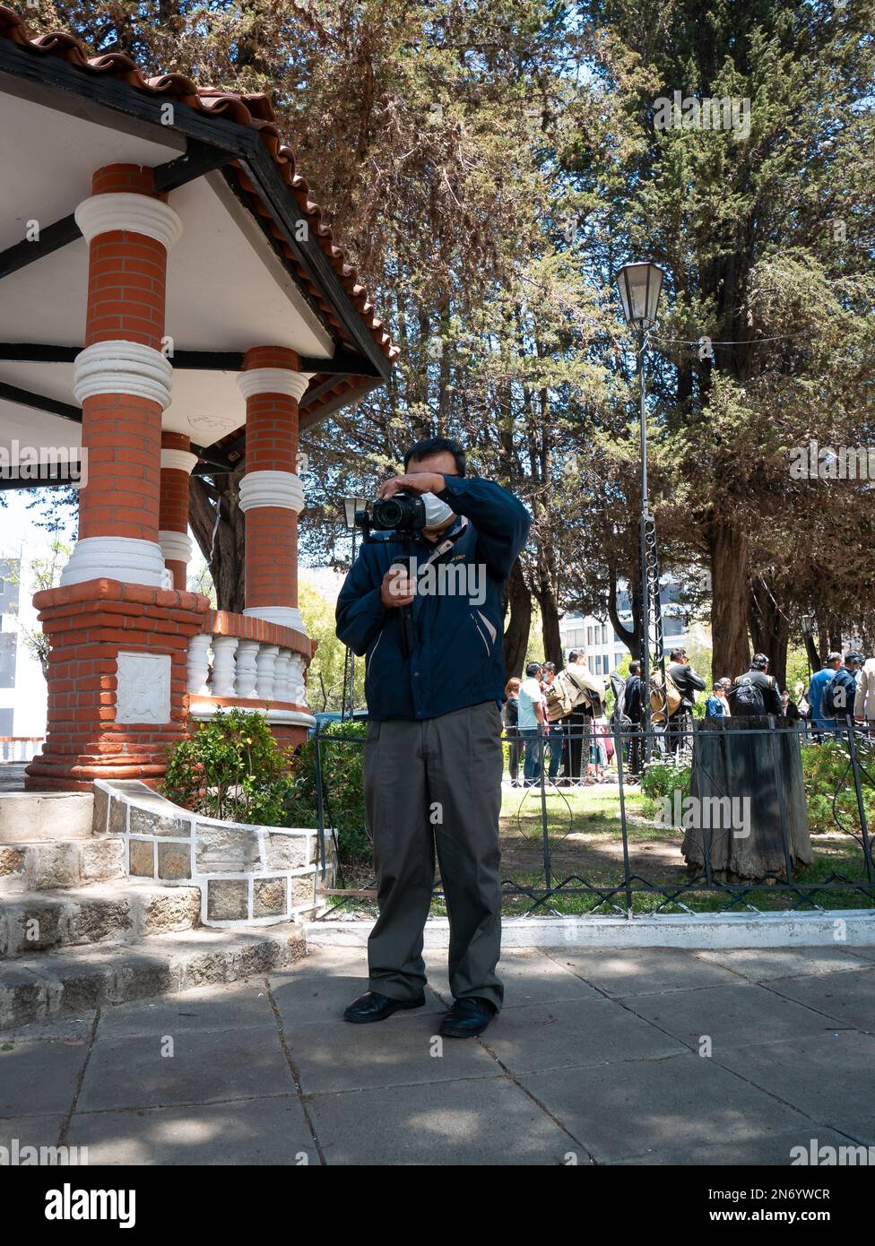 La Paz, Bolivia - Ottobre 1 2022: Cameraman Record sulla strada, mentre molte persone sono in background Foto Stock