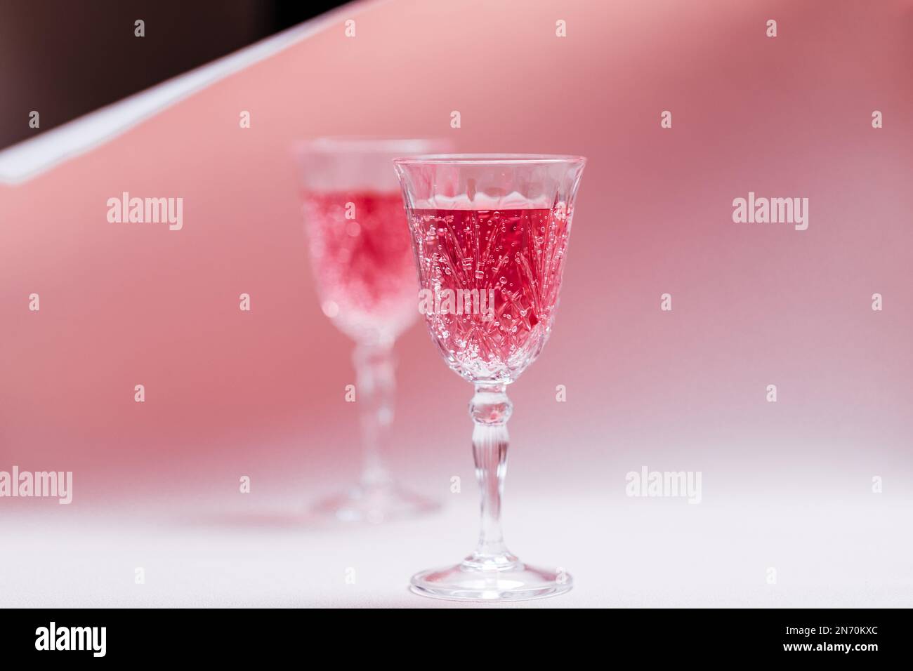 Coppia con due cocktail rosa per la celebrazione di San Valentino. L'amore e l'anniversario impostazione con i cuori. Concetto romantico Foto Stock