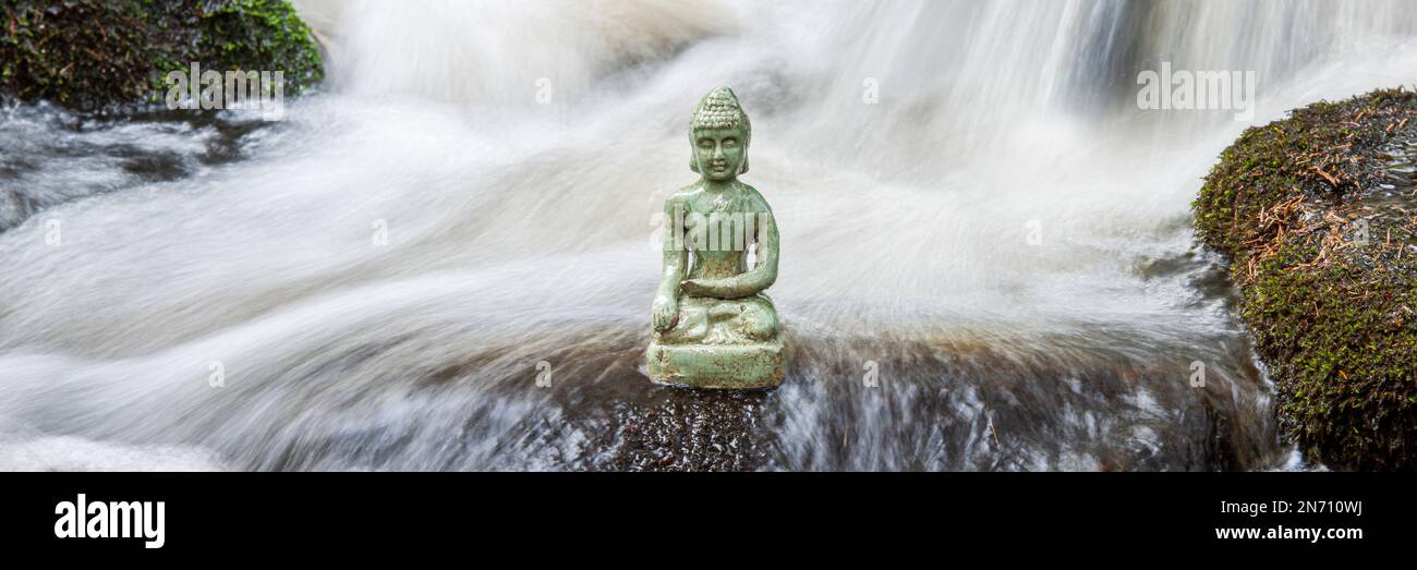 Scultura di Buddha seduta in acqua corrente Foto Stock