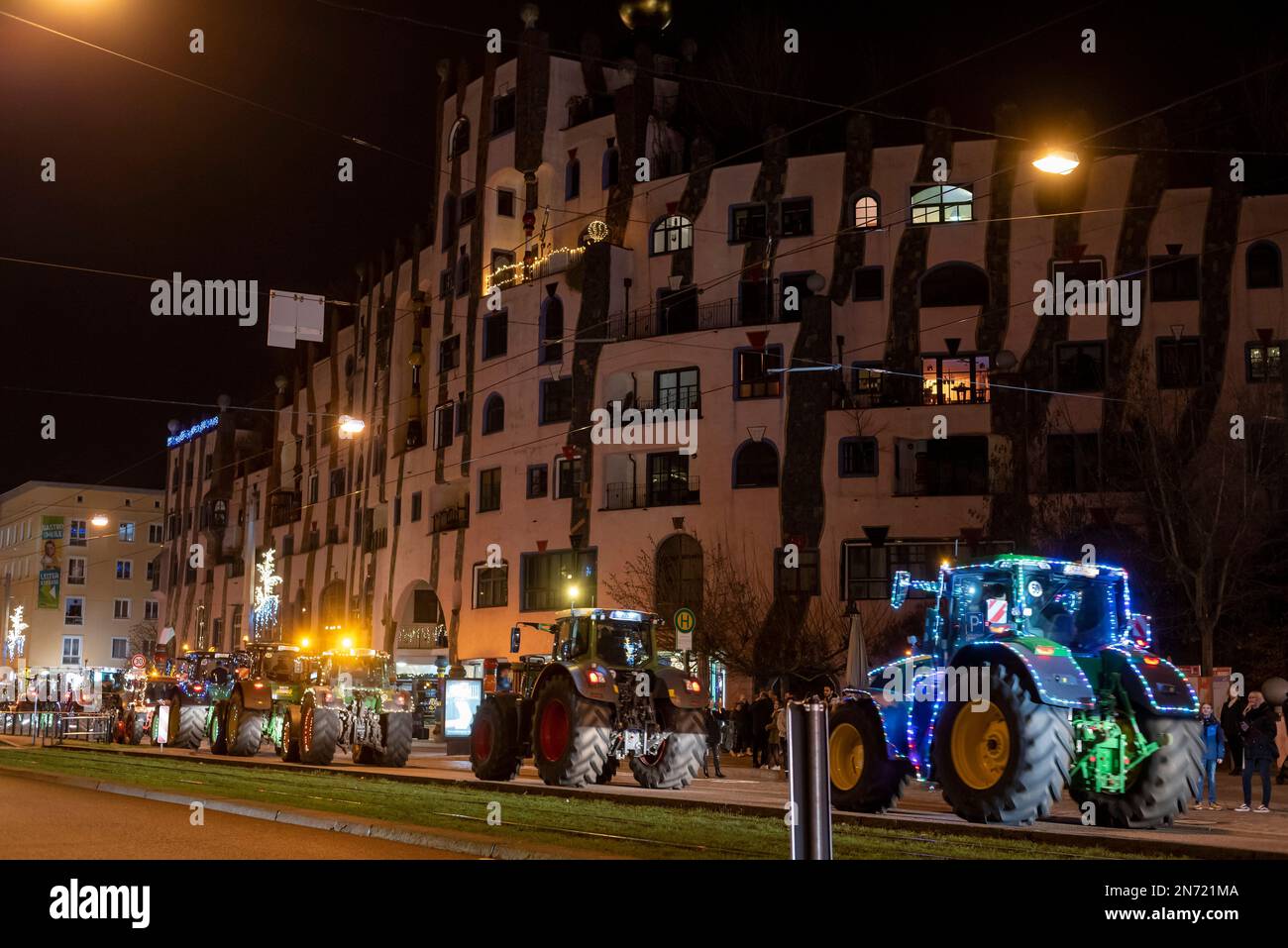 Trattori illuminati, giro leggero degli agricoltori tradizionali a Capodanno, Hundertwasserhaus, Magdeburg, Sassonia-Anhalt, Germania Foto Stock