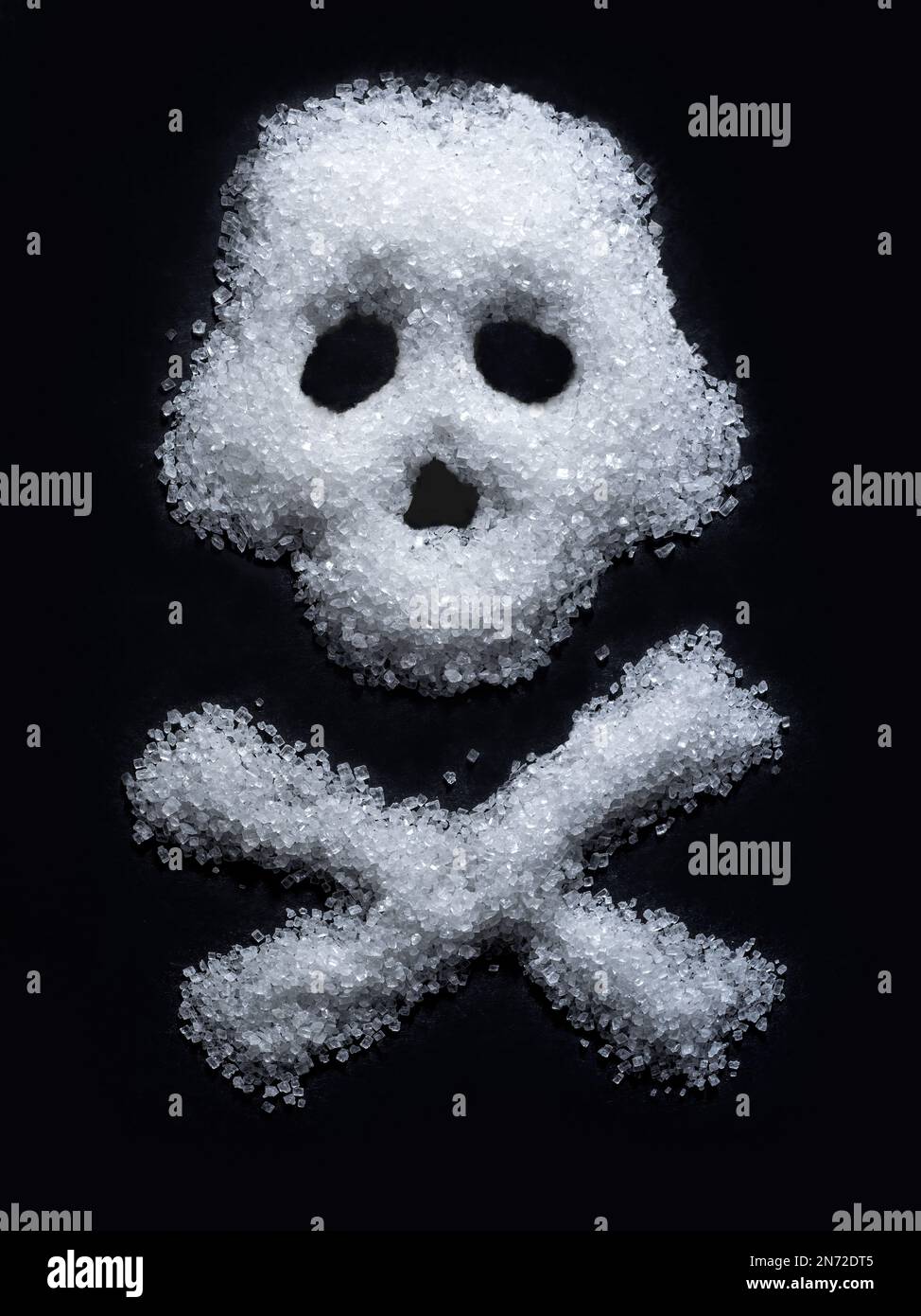 Forma del cranio disposta a partire da zucchero bianco su fondo nero Foto Stock