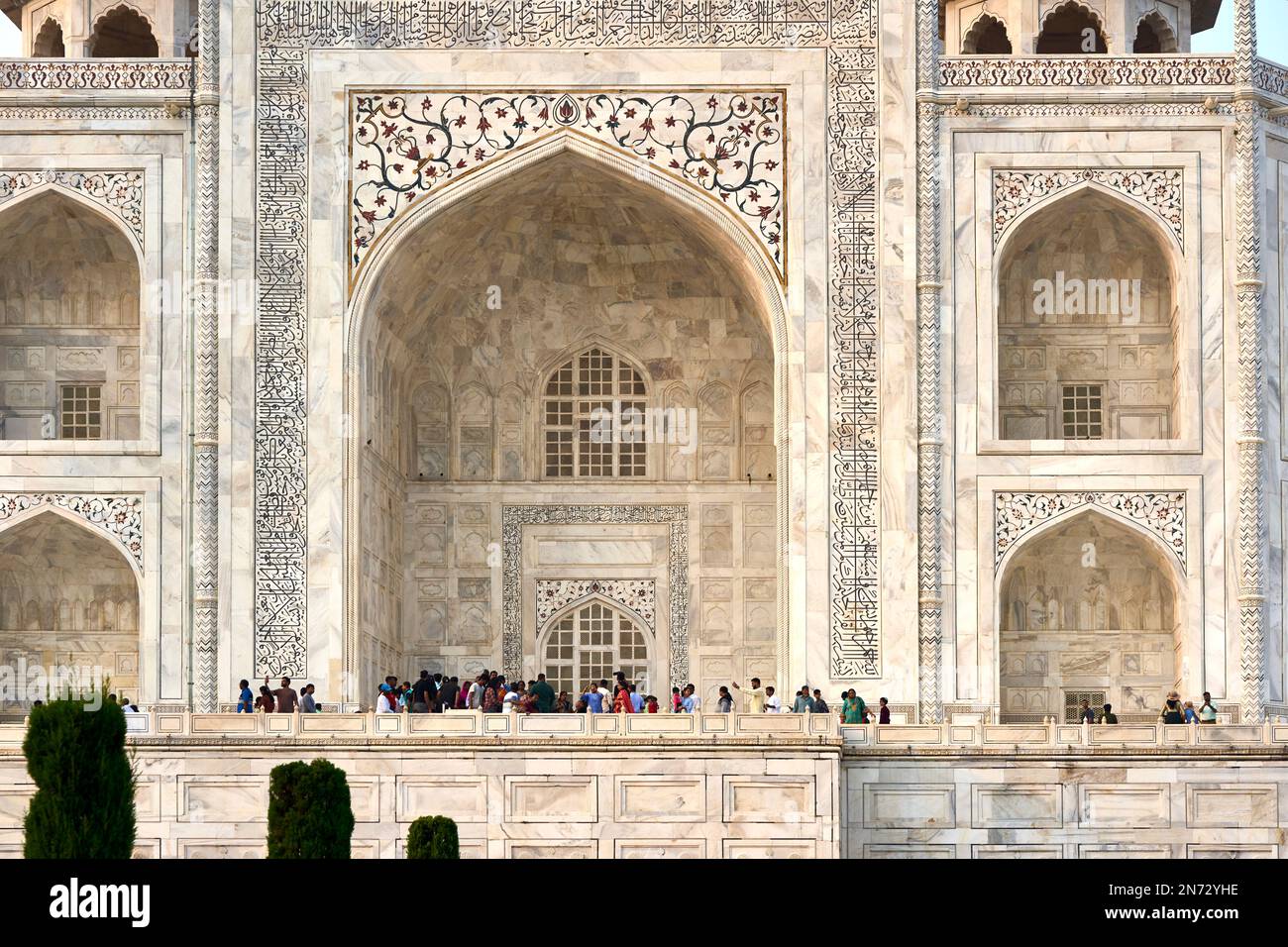 Turisti in visita alla facciata di marmo del mausoleo del Taj Mahal ad Agra Foto Stock