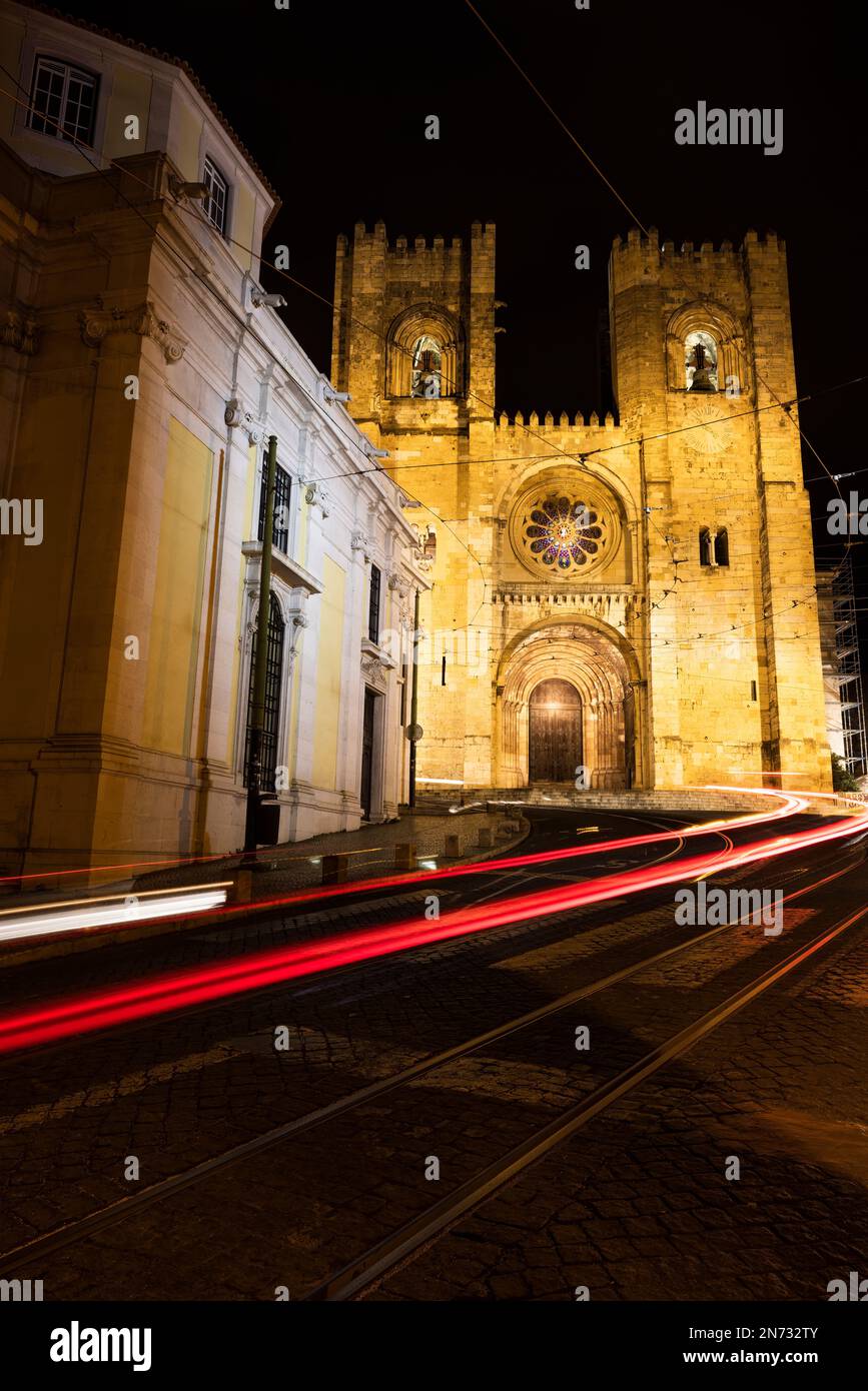 Una foto a lunga esposizione del traffico notturno di Lisbona di fronte alla Catherdal se de Lisbona Foto Stock