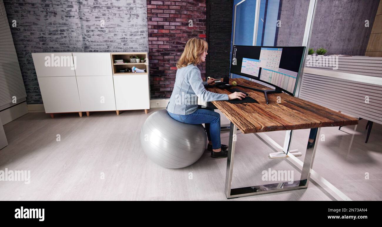 Correggere la postura alla scrivania in ufficio usando la sfera di idoneità Foto Stock
