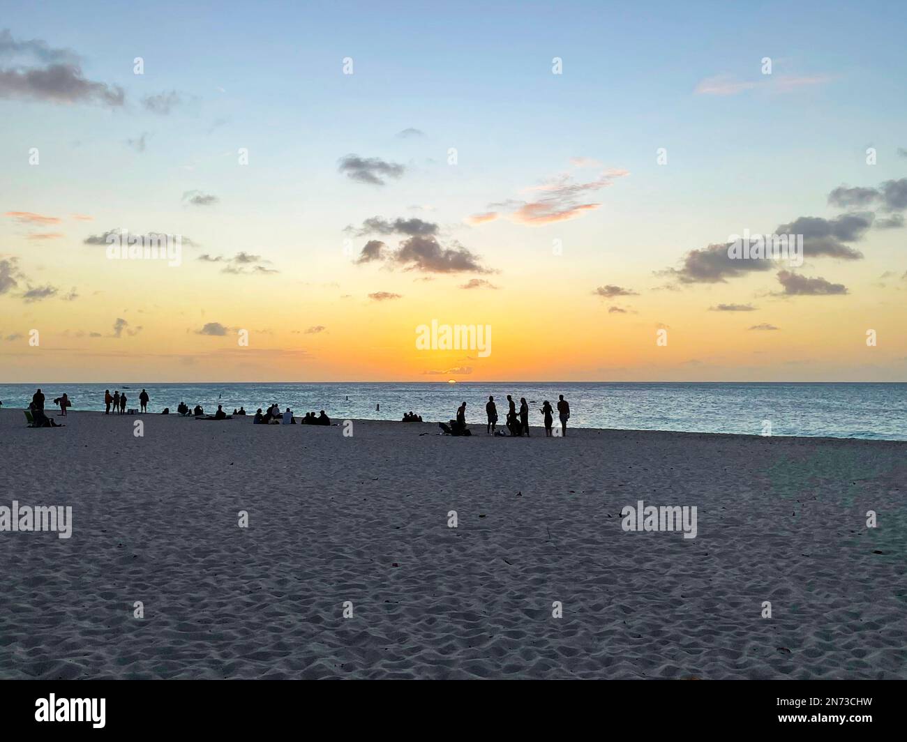 Silhouette di un gruppo di persone sulla spiaggia di Aruba, al tramonto. Foto Stock