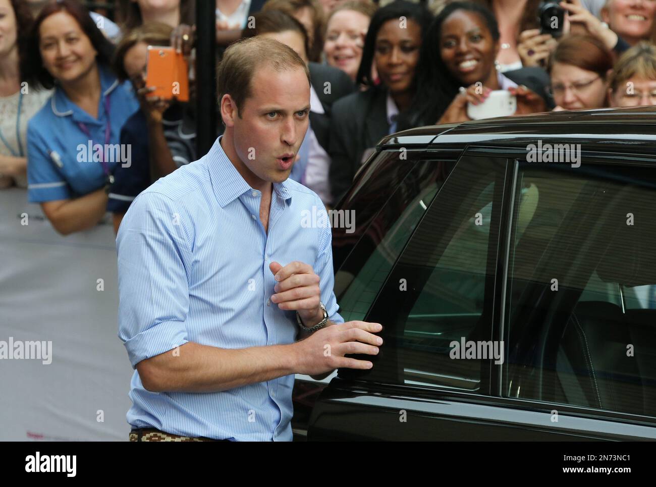 The Duke of Cambridge breathes a sigh after carrying the Prince of Cambridge outside for the first time to the awaiting car, at St Mary's Hospital in Paddington, west London, Monday, July 23, 2013. The boy, who is third in line to the British throne, has since been named George Alexander Louis by his parents and will be known as Prince George of Cambridge. (Photo by Joel Ryan/Invision/AP) Foto Stock