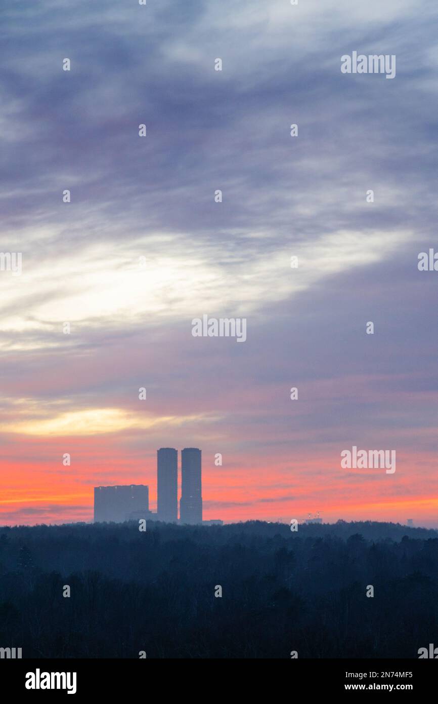 nuvole nel cielo dell'alba sopra il parco cittadino e le torri al freddo mattino Foto Stock