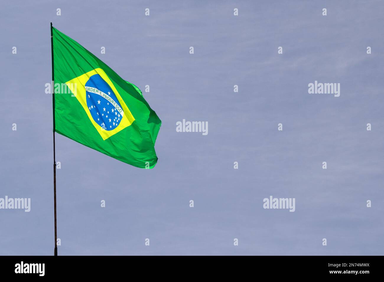 Goiania, Goiás, Brasile – 02 ottobre 2022: Una bandiera brasiliana che sventolava nel vento con il cielo sullo sfondo. Foto Stock
