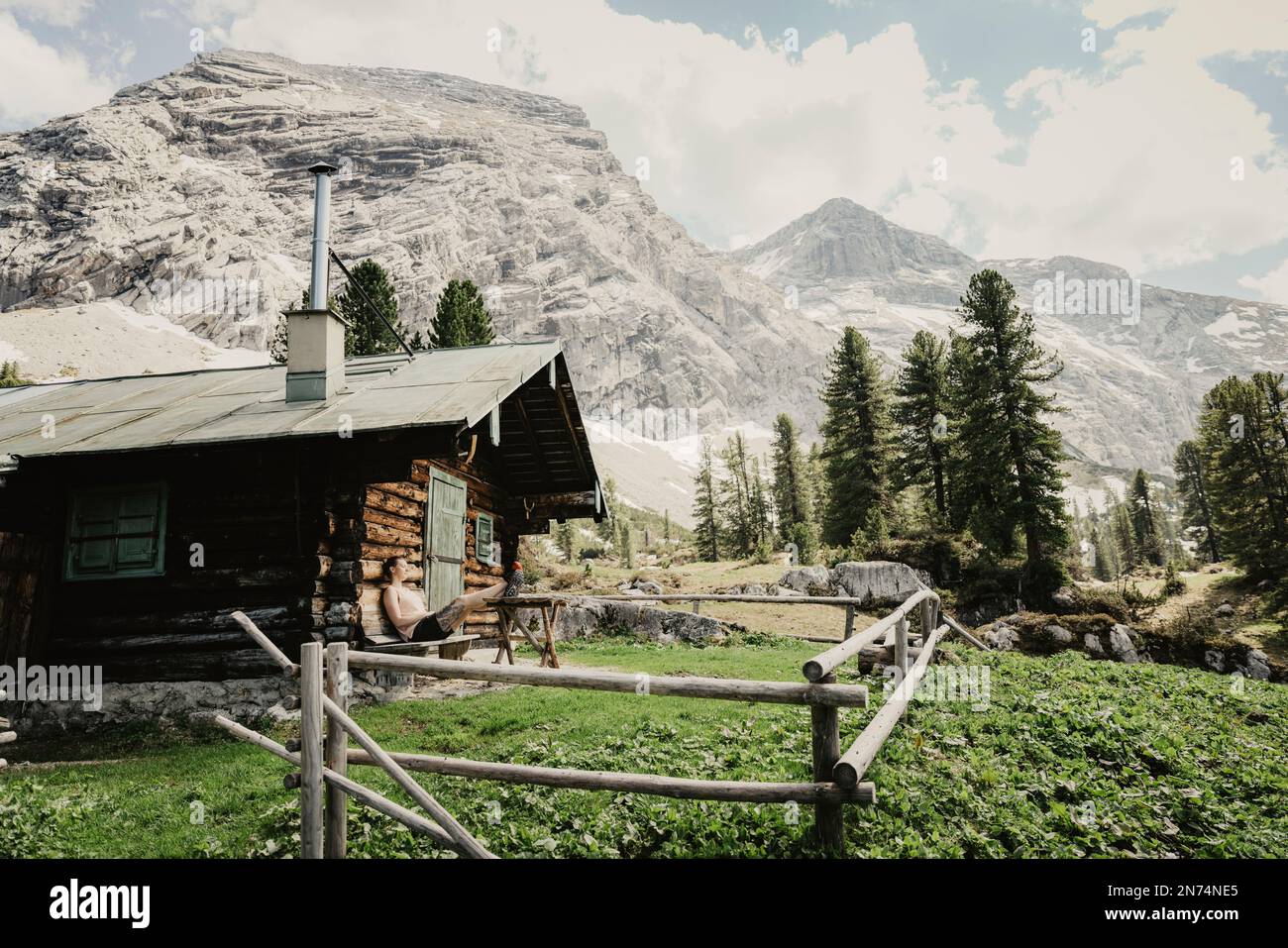 Donna su un grande sentiero che corre intorno alla Schachenhaus di re Ludwig nei monti Wetterstein, Baviera, Germania, capanna, pausa Foto Stock