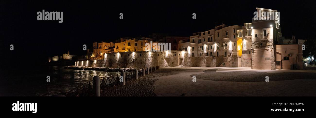 Mura della città splendidamente illuminate sulla costa di Vieste in Gargano, Italia Foto Stock