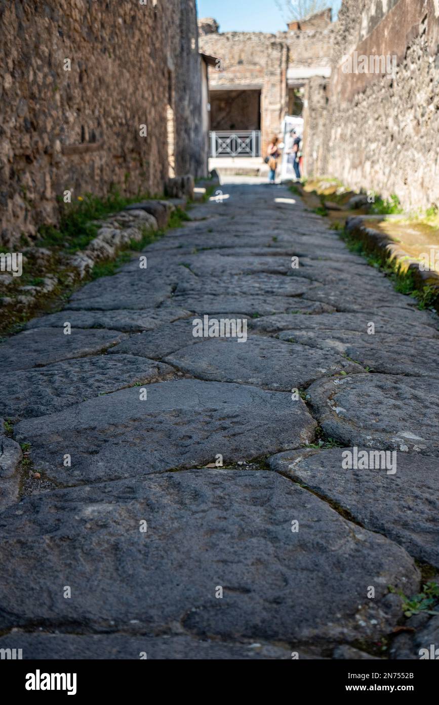 Una bella strada acciottolata tipica nell'antica città di Pompei, nel sud dell'Italia Foto Stock