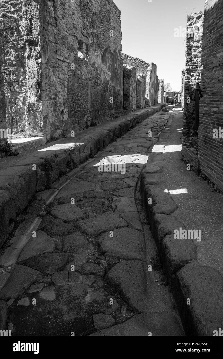 Una bella strada acciottolata tipica nell'antica città di Pompei, nel sud dell'Italia Foto Stock