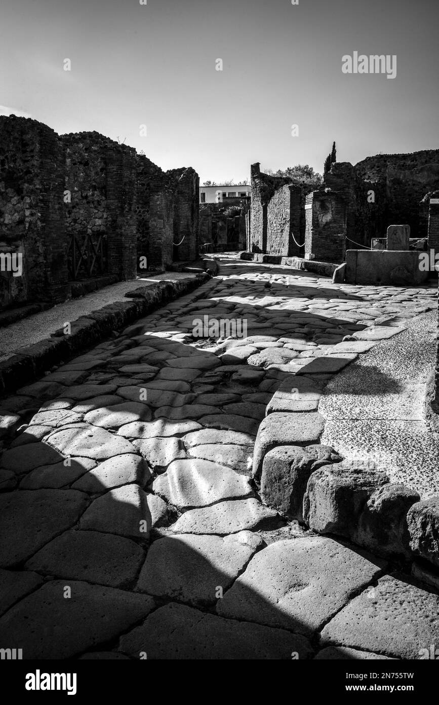 Una bella strada acciottolata tipica nell'antica città di Pompei, nel sud dell'Italia Foto Stock