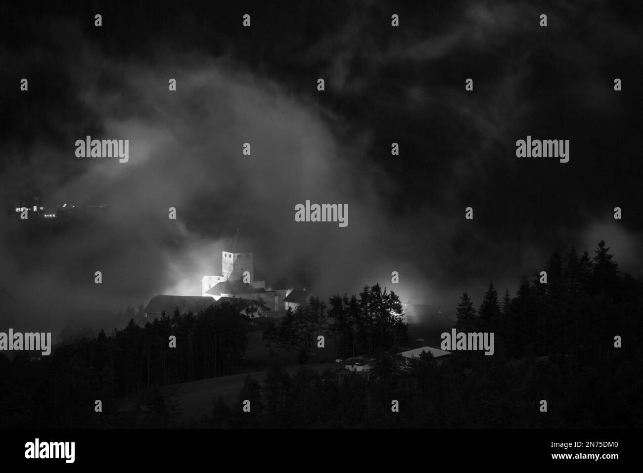 Castello medievale di Spooky a San Martino in Turn, nascosto dietro basse nuvole pendenti, provincia autonoma del Tirolo del Sud in Italia Foto Stock