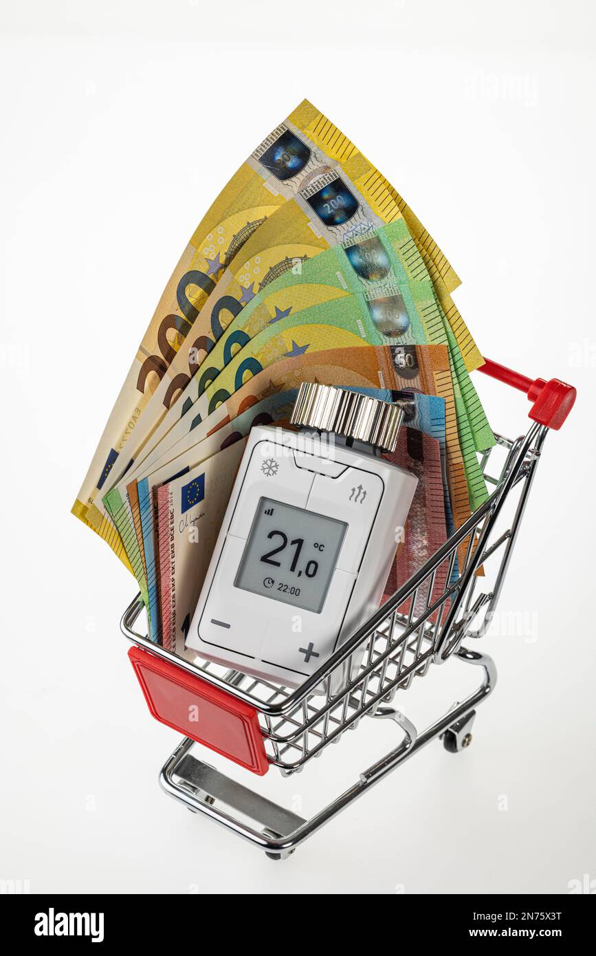 Carrello, bollette in euro, termostato per radiatori WLAN, FRITZ! DECT 302, il display visualizza 2ö°C., tecnologia smart home, immagine simbolo, rete, digitale, acquisti, costi energetici, aumento dei costi di riscaldamento, sfondo bianco, Foto Stock