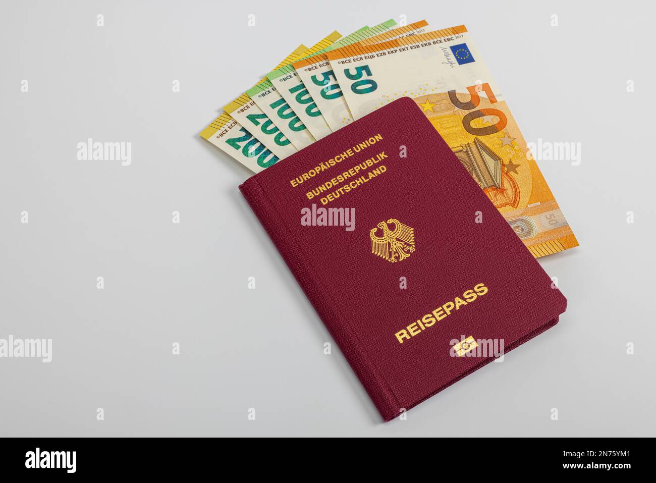 Passaporto della Repubblica federale di Germania con varie banconote in euro, sfondo bianco, Foto Stock