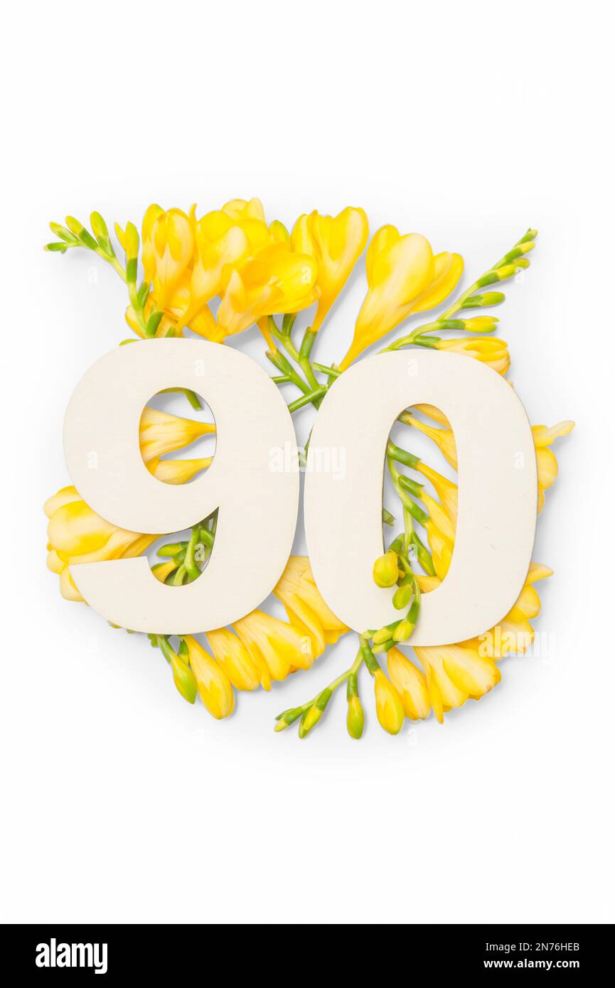 Numero novanta forma con brunch di fiore giallo freesia isolato su sfondo bianco. Concetto estivo. Giacitura piatta. Vista dall'alto Foto Stock