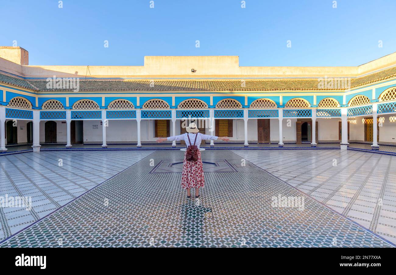 Un giovane turista a braccia aperte che guarda cortile a El Bahia Palace, Marrakech, Marocco Foto Stock